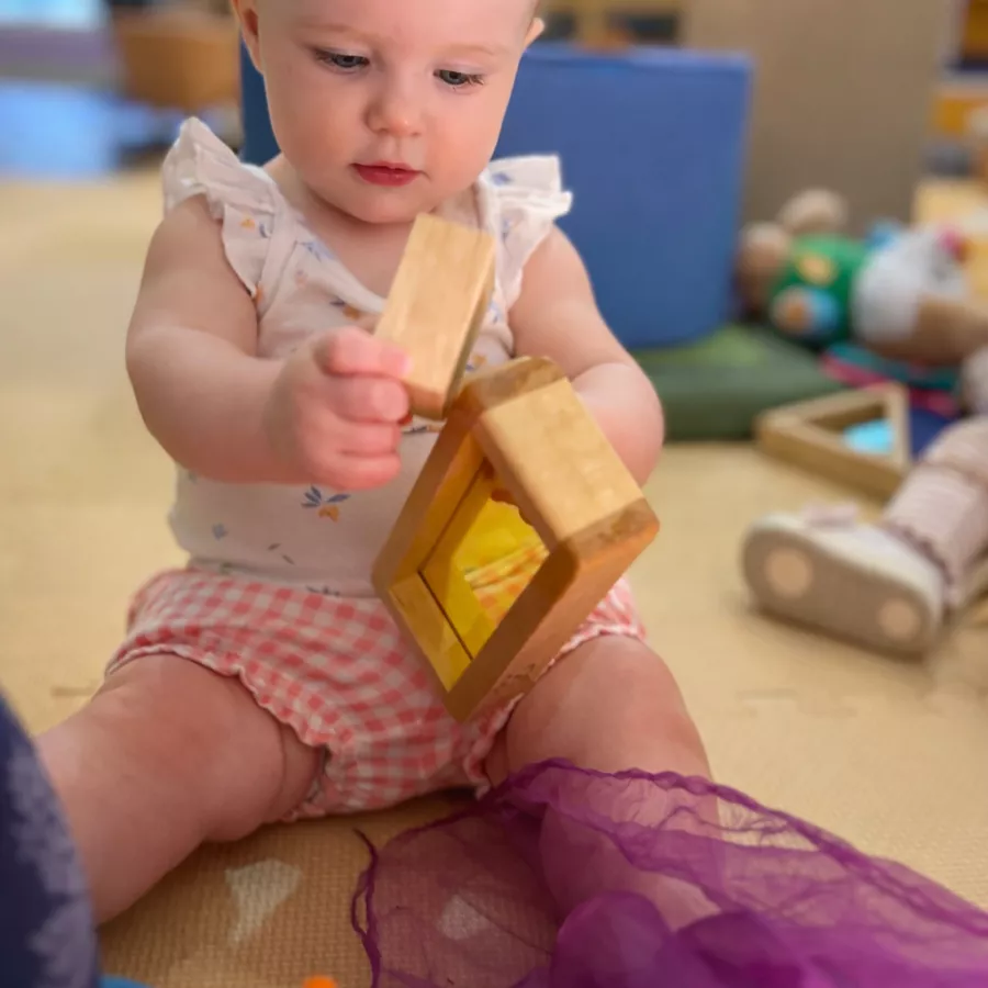 Infant in baby nido program engaging with light and blocks